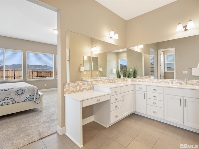 ensuite bathroom featuring tile patterned flooring, vanity, ensuite bathroom, and baseboards