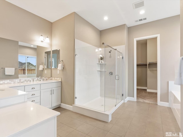 bathroom with vanity, a garden tub, visible vents, and a stall shower