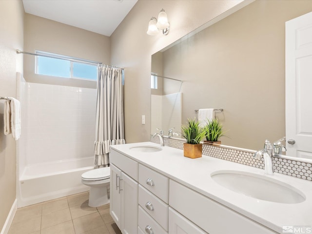 bathroom with tile patterned flooring, toilet, shower / tub combo with curtain, and a sink