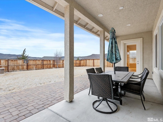 view of patio with outdoor dining space and fence