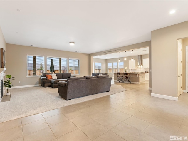 living room featuring visible vents, light tile patterned floors, light colored carpet, and baseboards