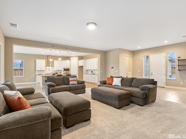 living area featuring visible vents, light tile patterned floors, recessed lighting, and baseboards