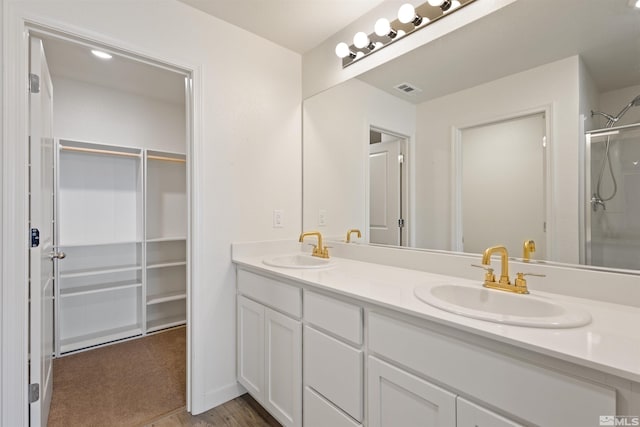 full bathroom featuring a spacious closet, visible vents, and a sink