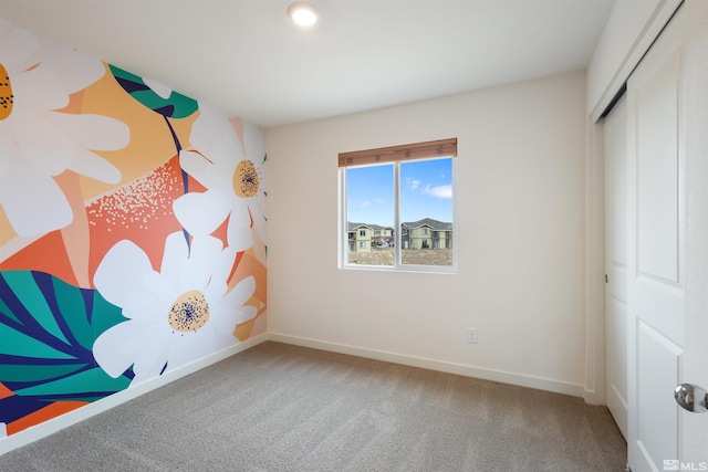 unfurnished bedroom with carpet flooring, baseboards, and a closet