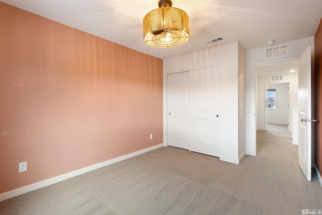 unfurnished bedroom featuring light colored carpet, visible vents, and baseboards