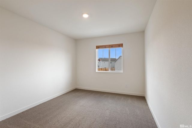 empty room with baseboards and carpet