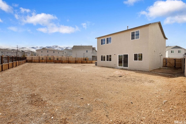 back of property with stucco siding and a fenced backyard