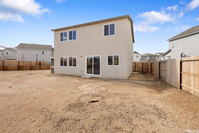 back of house featuring a fenced backyard and stucco siding