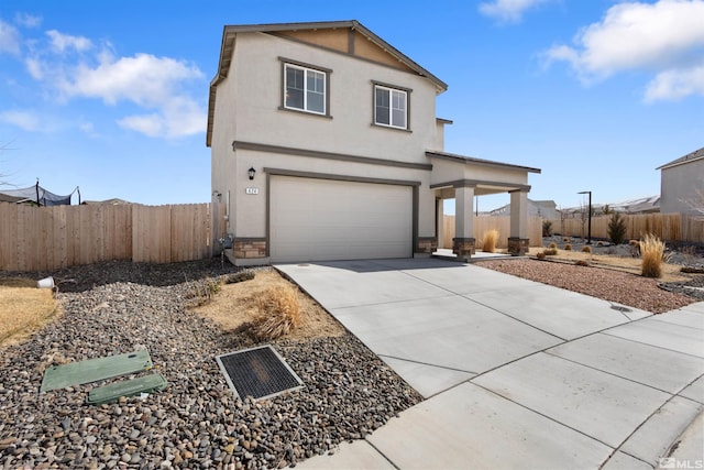 traditional-style house featuring stucco siding, an attached garage, driveway, and fence