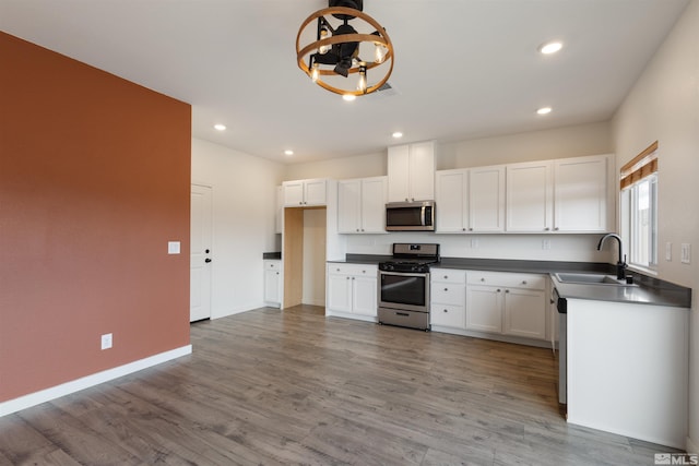 kitchen with visible vents, a notable chandelier, a sink, dark countertops, and stainless steel appliances