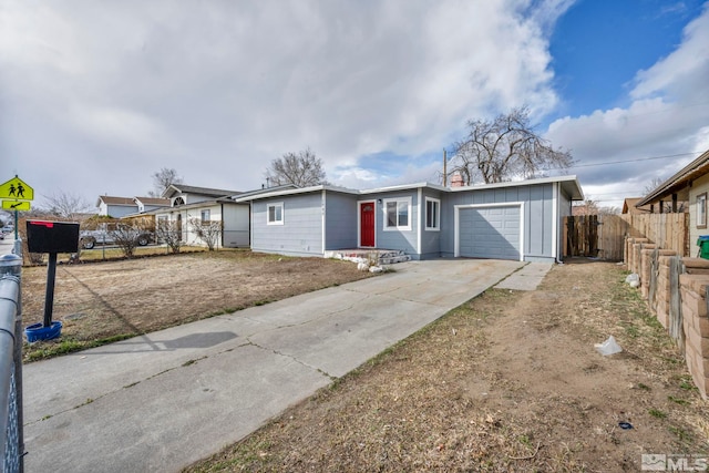 ranch-style house with concrete driveway, an attached garage, fence, and board and batten siding