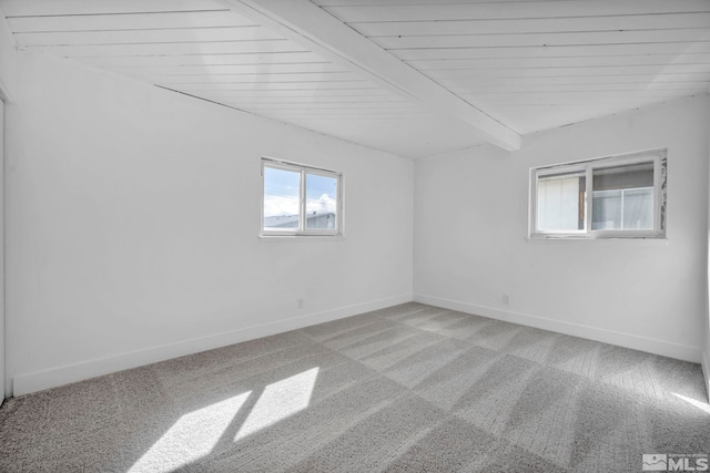 empty room with beamed ceiling, wood ceiling, baseboards, and light carpet