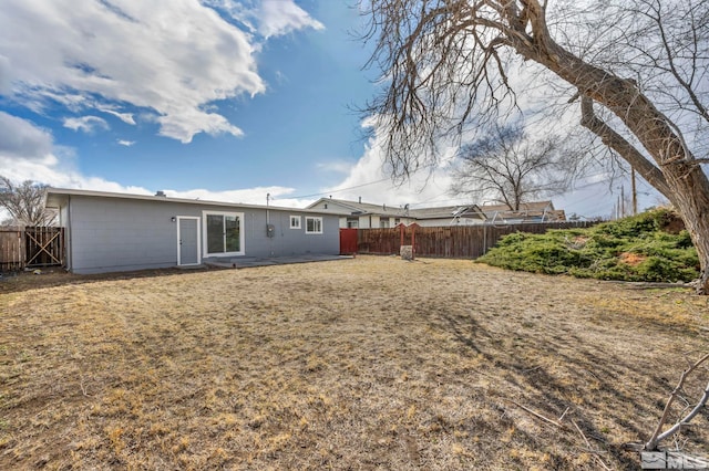 back of property with concrete block siding and fence