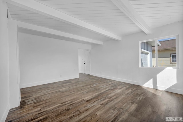 spare room with baseboards, beam ceiling, and dark wood-type flooring