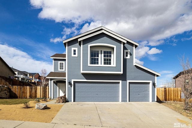 traditional home with an attached garage, fence, and driveway