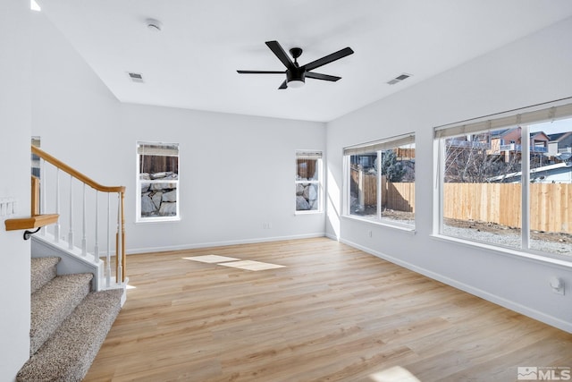 interior space featuring visible vents, light wood-style floors, ceiling fan, and stairs