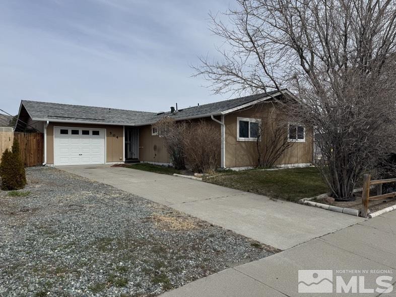 ranch-style house with concrete driveway, an attached garage, and fence