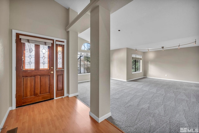 entryway featuring visible vents, wood finished floors, baseboards, and carpet floors