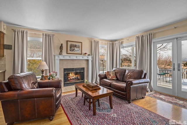 living room featuring a fireplace, light wood-type flooring, and a textured ceiling