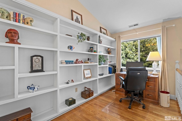 office with lofted ceiling, wood finished floors, and visible vents