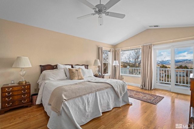 bedroom featuring visible vents, vaulted ceiling, wood finished floors, a ceiling fan, and access to outside