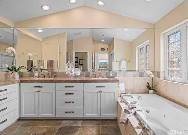 bathroom featuring vaulted ceiling and a sink