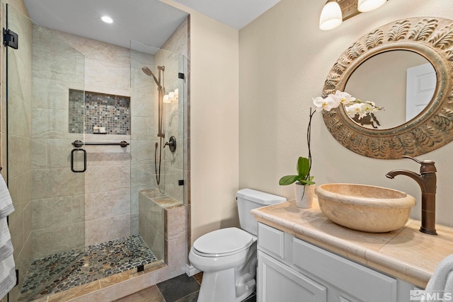 bathroom featuring vanity, a shower stall, toilet, and recessed lighting