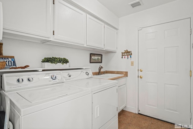 laundry room featuring visible vents, washer and clothes dryer, a sink, cabinet space, and light tile patterned floors