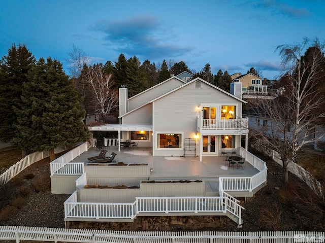 rear view of house featuring a fenced backyard, outdoor dining space, and a balcony