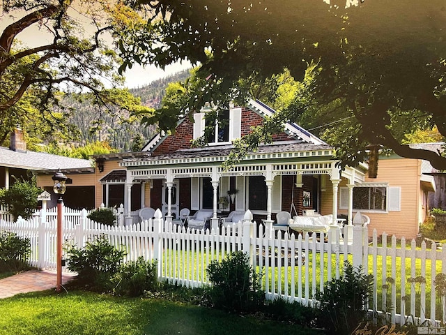 view of front facade featuring a fenced front yard, a porch, and a front lawn