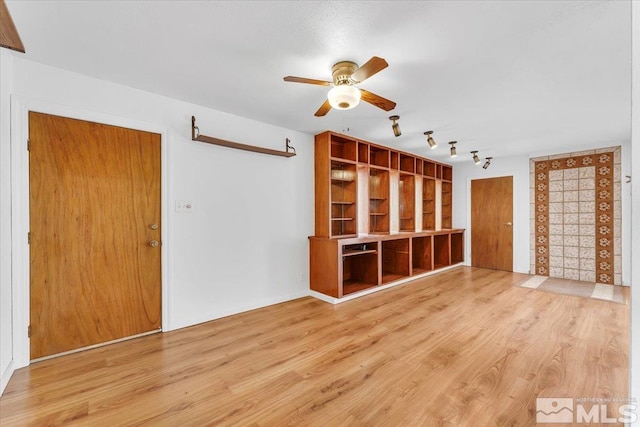 unfurnished living room featuring rail lighting, wood finished floors, and ceiling fan