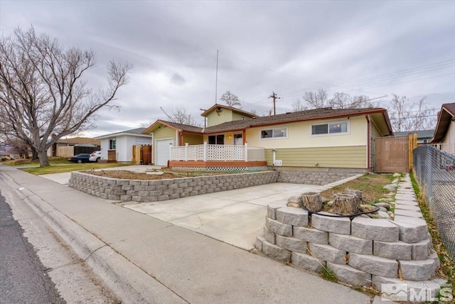 ranch-style house with an attached garage, driveway, and fence