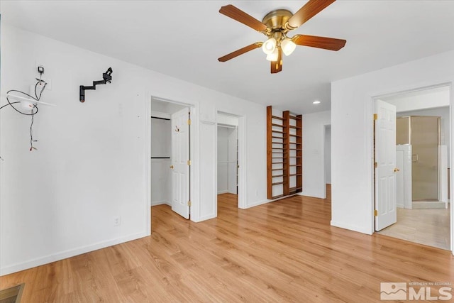 interior space featuring ceiling fan, visible vents, baseboards, and light wood-style flooring