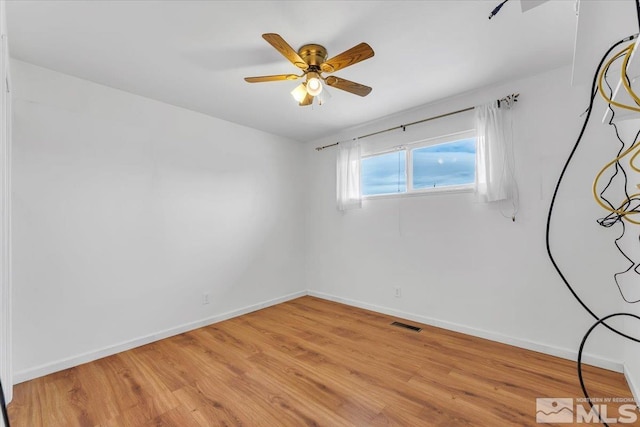 unfurnished room featuring light wood finished floors, visible vents, a ceiling fan, and baseboards