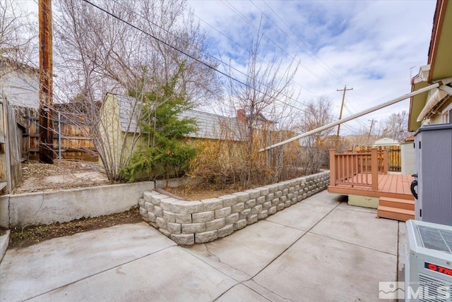 view of patio with a deck and fence