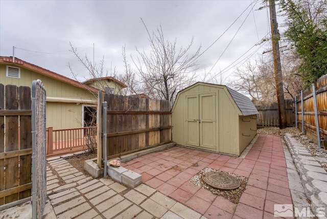 view of patio / terrace with an outdoor structure, a fenced backyard, and a shed