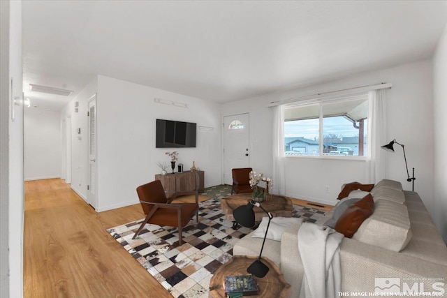 living area with light wood-style floors and baseboards