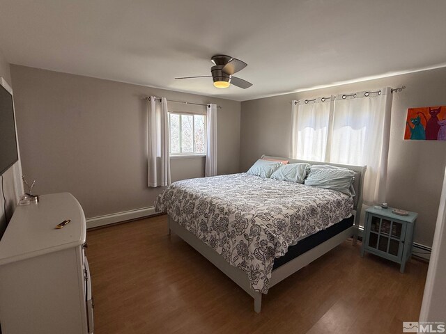 bedroom with a baseboard heating unit, baseboards, a ceiling fan, and dark wood-style flooring