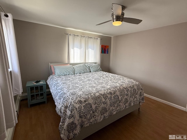 bedroom featuring ceiling fan, baseboards, and wood finished floors