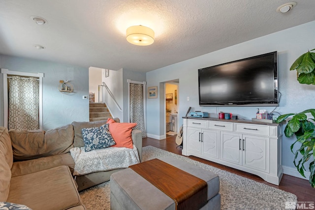 living area featuring stairs, dark wood-style floors, baseboards, and a textured ceiling