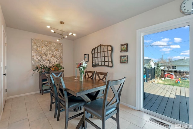 dining room with light tile patterned floors, visible vents, baseboards, and a chandelier