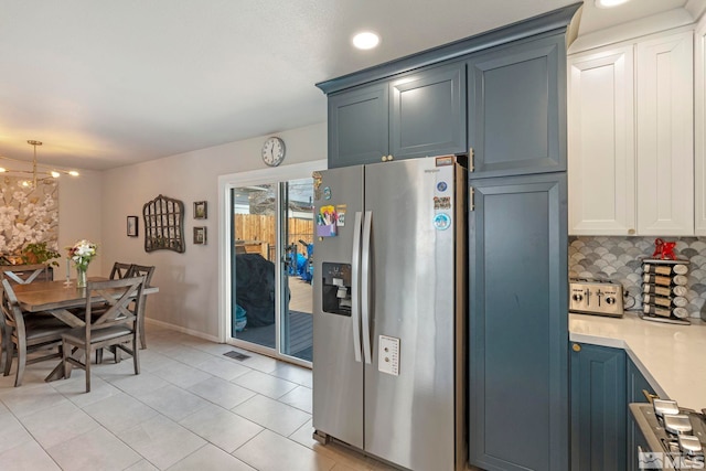 kitchen with tasteful backsplash, visible vents, stainless steel fridge with ice dispenser, light countertops, and a notable chandelier