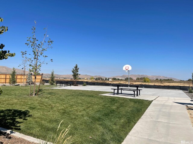 surrounding community featuring community basketball court, a lawn, and a mountain view