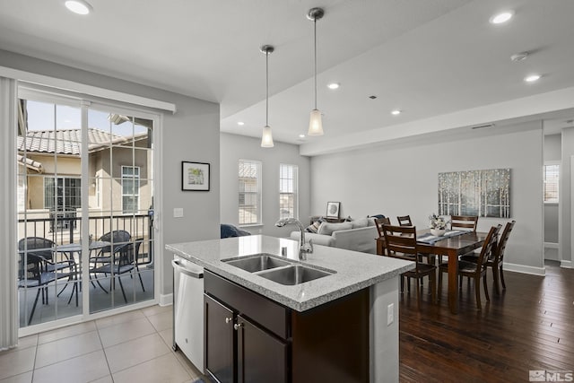 kitchen featuring stainless steel dishwasher, dark brown cabinetry, plenty of natural light, and a sink