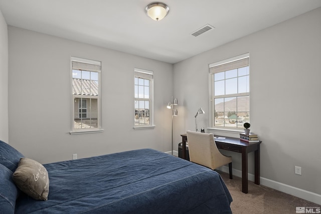 carpeted bedroom featuring visible vents and baseboards