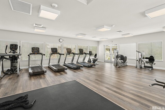 exercise room featuring visible vents, baseboards, and wood finished floors