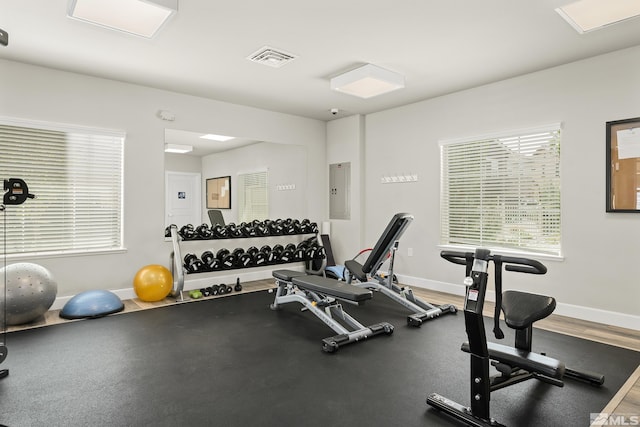 gym featuring electric panel, visible vents, and baseboards