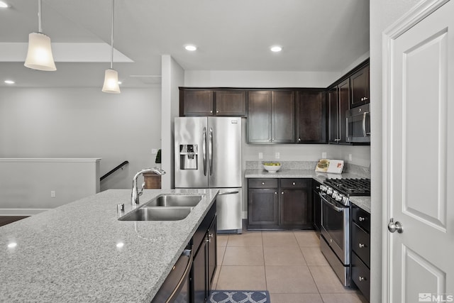 kitchen featuring a sink, light stone counters, appliances with stainless steel finishes, light tile patterned flooring, and dark brown cabinets