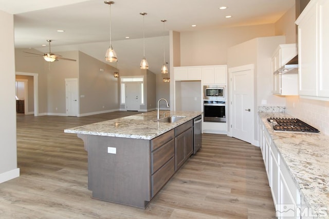 kitchen featuring appliances with stainless steel finishes, white cabinetry, and a sink