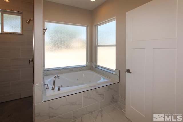 full bathroom featuring marble finish floor, a tile shower, and a whirlpool tub